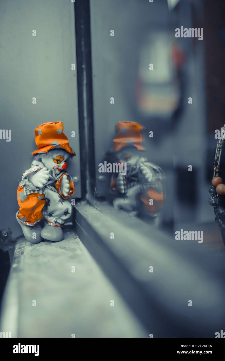 mécontent clown jouet gros plan. arrière-plan bokeh. devant la fenêtre clown jouet triste. attente Banque D'Images