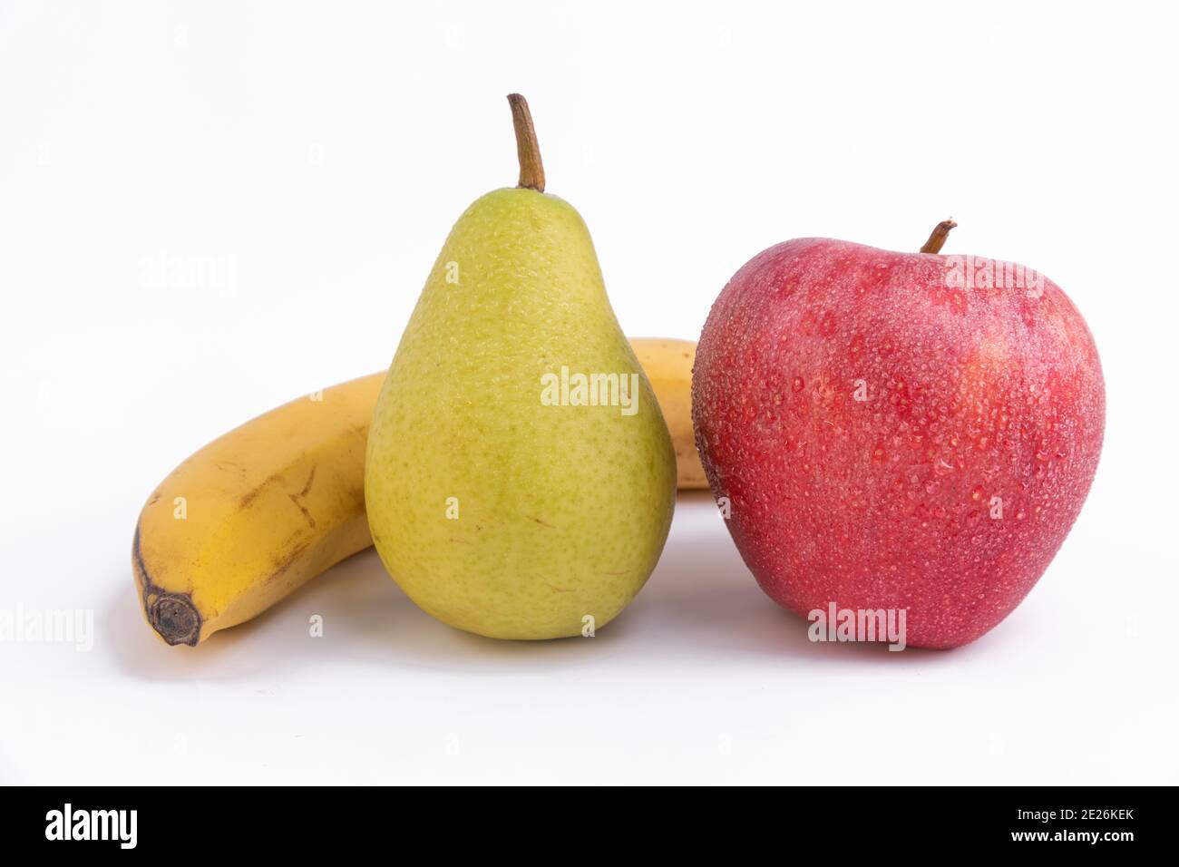 Gros plan d'une pomme rouge fraîche avec une banane et poire isolée sur fond blanc Banque D'Images