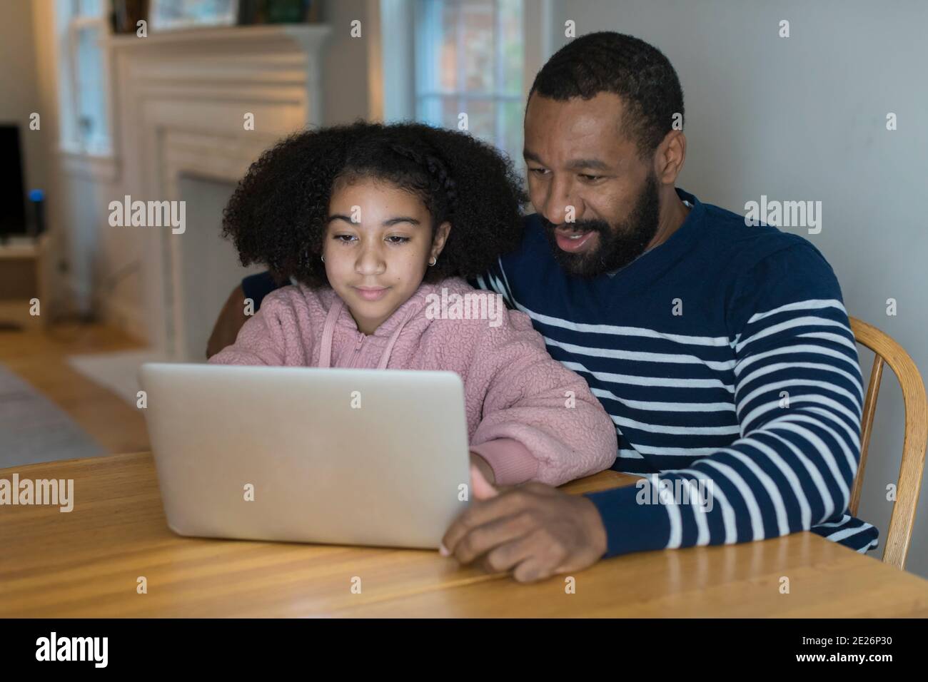 Un père afro-américain et une fille d'intermédiaire bi-raciale sur ordinateur portable Banque D'Images