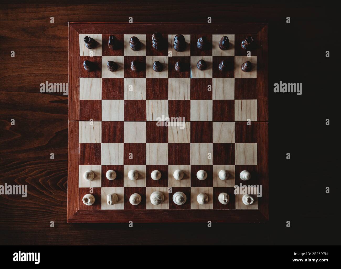 Vue en hauteur d'un échiquier en bois et de pièces sur une table. Banque D'Images
