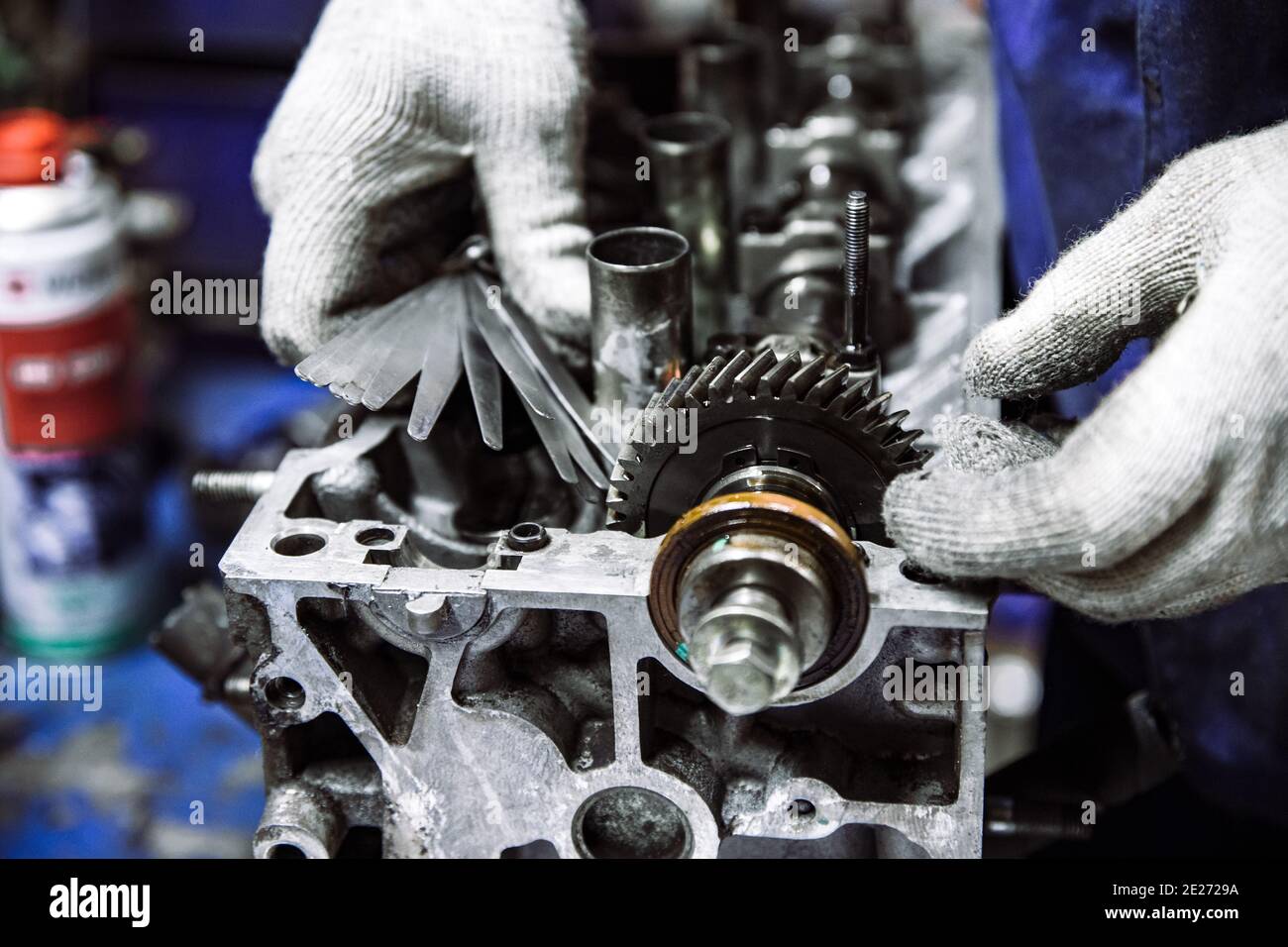 Vilebrequin d'un moteur à combustion interne et main de travail avec des gants et une faible profondeur de champ Banque D'Images