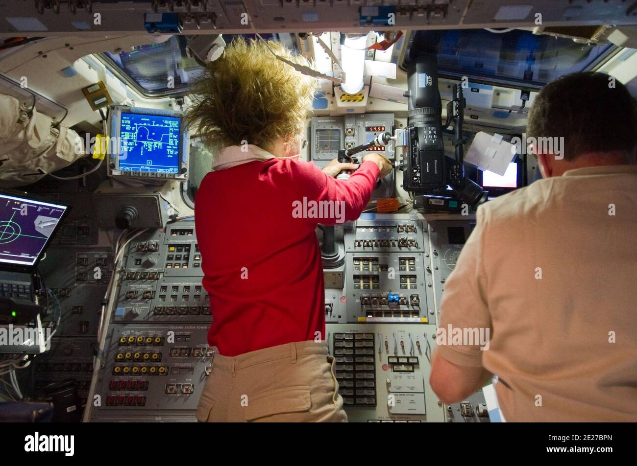 L'astronaute de la NASA Sandy Magnus, spécialiste de la mission STS-135, est photographié aux commandes de la plate-forme de la navette spatiale Atlantis pendant les opérations de rendez-vous et d'amarrage avec la Station spatiale internationale. L'astronaute de la NASA Rex Walheim, spécialiste de la mission, est à droite. 10 juillet 2011. Photo de la NASA via ABACAPRESS.COM Banque D'Images