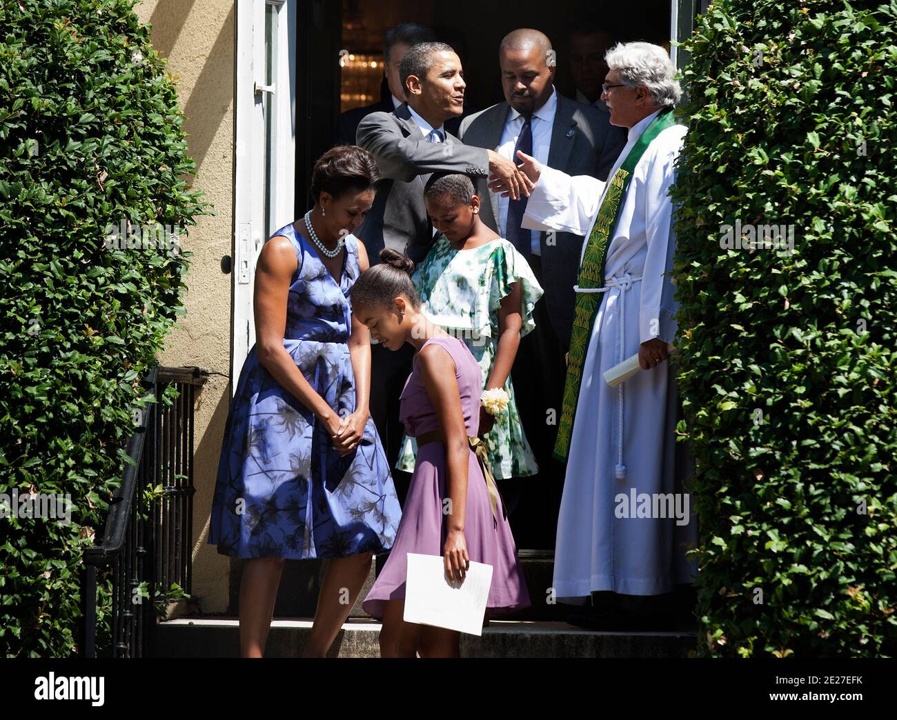 Le président Barack Obama secoue la main du révérend Luis Leon (R) tout en partant avec la première dame Michelle Obama (L) et leurs filles Malia (2L) et Sasha (3R) de l'église épiscopale protestante Saint-Jean pour la Maison Blanche à Washington, DC., le 17 juillet 2011. La première famille a assisté aux services du dimanche. Photo de Brendan Smitalowski/Bloomberg News/ABACAPRESS.COM Banque D'Images