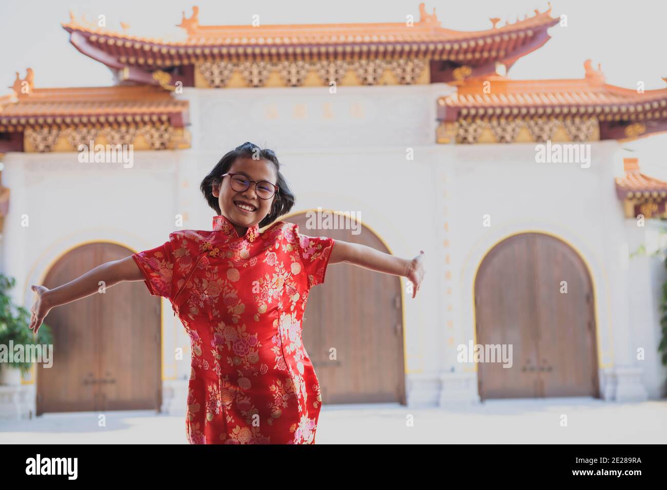 fille asiatique portant un costume chinois rouge bonheur contre le temple de chine arrière-plan Banque D'Images