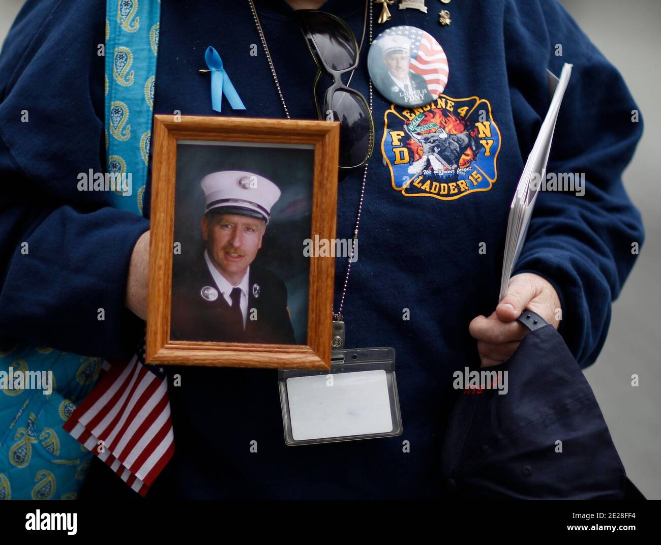 Un pompier de New York tient une photographie d'un camarade lors des cérémonies marquant le 10e anniversaire des attaques de 9/11 contre le World Trade Center le 11 septembre 2011, à New York le 11 septembre 2011, à New York. Photo de Lucas Jackson/ABACAUSA.COM photo pool/ABACAPRESS.COM Banque D'Images