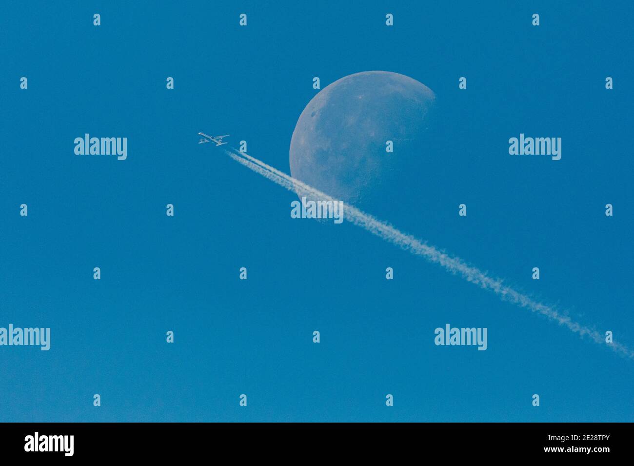 Lune en déclin, en premier plan un avion de ligne commercial avec des contrailles, Allemagne, Bavière Banque D'Images