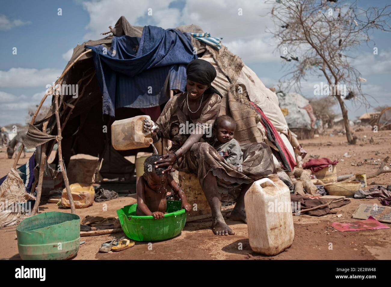 Mumina, âgée de 30 ans, est originaire de Jilib, photographiée au camp de réfugiés de Dadaab, au Kenya, le 20 août 2011. Elle est venue ici avec six enfants en décembre 2010. La semaine dernière, le HCR a mis en place un programme visant à relocaliser les réfugiés vivant dans des zones dangereuses. En cas de pluie, certaines parties de Dadaab pourraient être inondées et le risque d'épidémie serait très élevé. Mais Mumina ne veut pas Va-t'en. Elle est inquiète pour son fils. Le petit garçon montre une protubérance, couleur rose. Il a été opéré et Mumina est sûr qu'il ne supporterait aucun voyage. C'est pourquoi Mumina veut attendre ici pour qu'il s'améliore, aussi longtemps que Banque D'Images