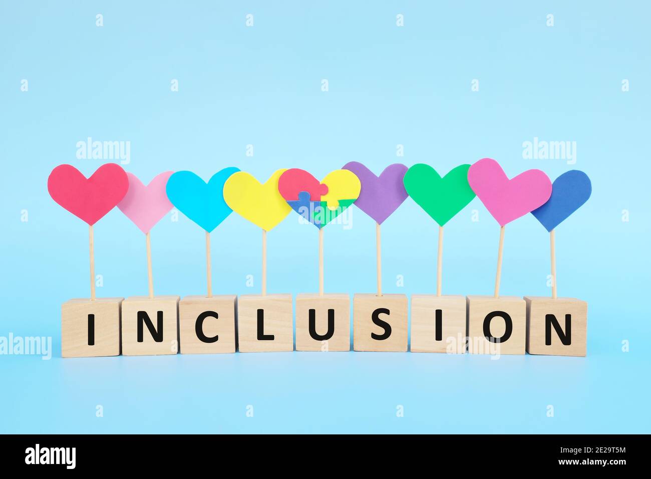 Concept de l'enfant avec le trouble du spectre autistique égalité, diversité et inclusion dans la société. Casse-tête en forme de coeur parmi un groupe multicolore. Banque D'Images