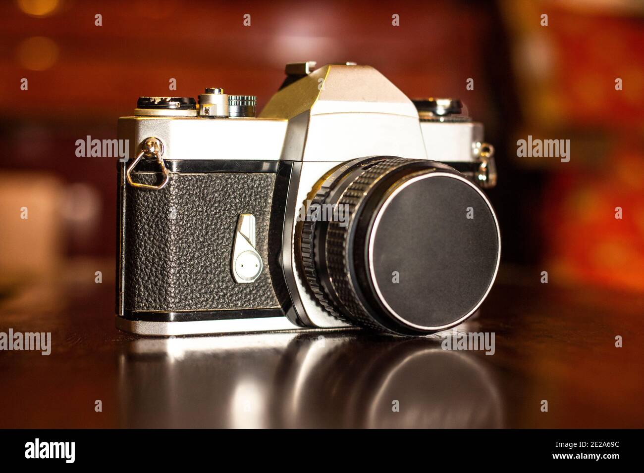 Gros plan d'un appareil photo vintage avec une partie en cuir noir sur une table en bois sur un arrière-plan flou Banque D'Images