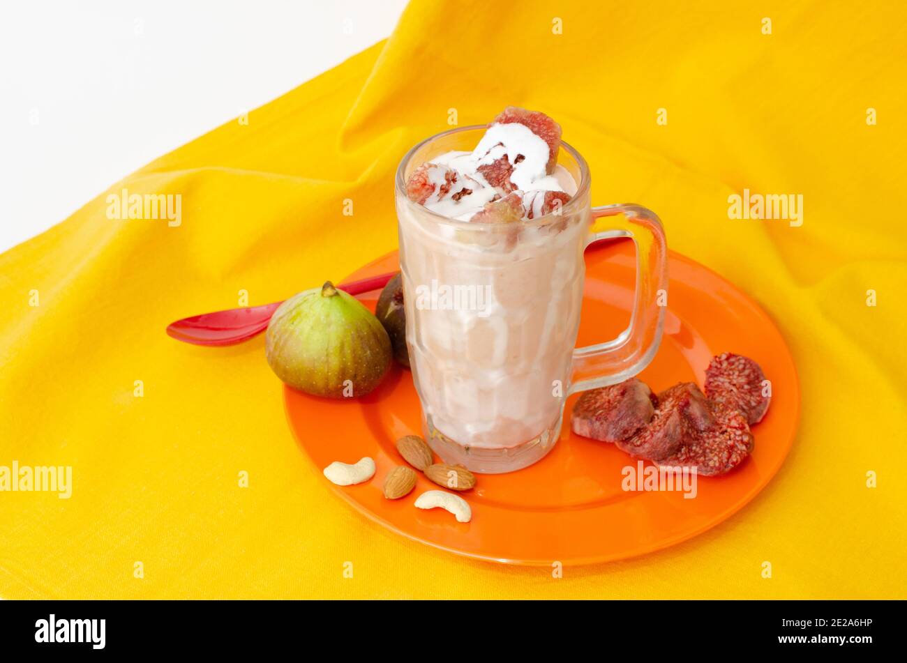 Milk-shake Anjeer ou à la figue Shake avec crème, morceaux de figues frais et fruits secs. Vue en angle supérieur, prise de vue en studio Banque D'Images