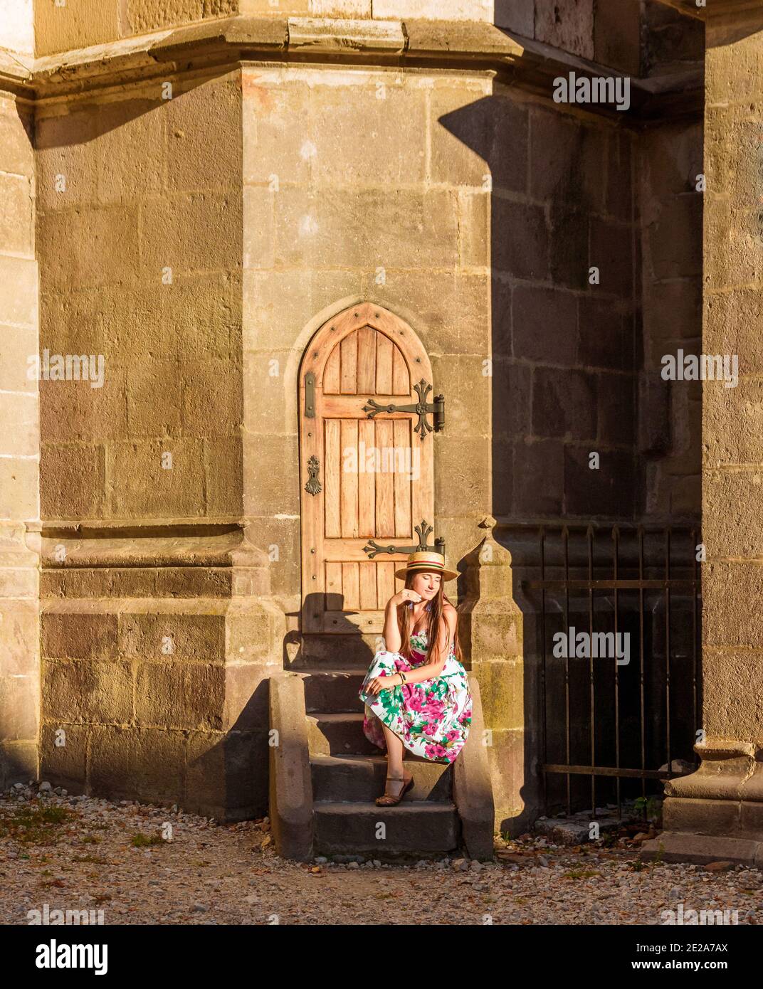 Une fille est assise sur un escalier près de l'église noire À Brasov Banque D'Images