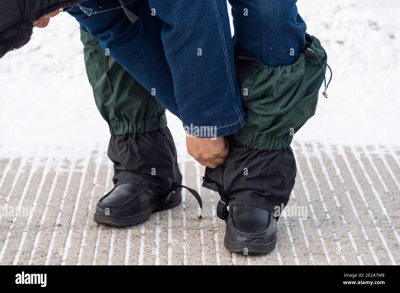 210113) -- MOHE, le 13 janvier 2021 (Xinhua) -- Lyu Jiansheng couvre ses  pattes de pantalon pour se protéger de la neige avant de faire une  patrouille de ligne électrique dans la