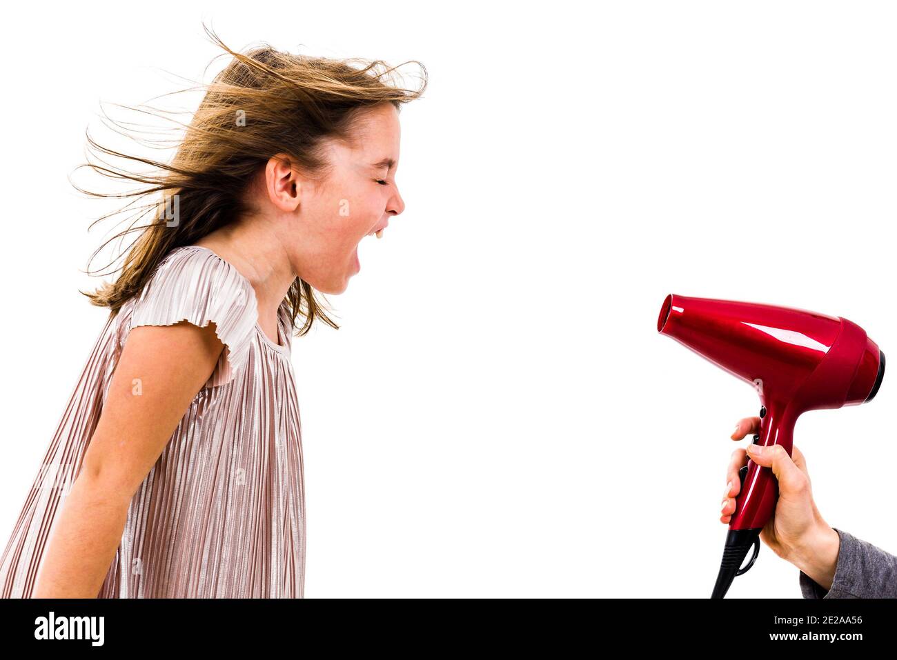 Fille est criant, criant à séchoir - sèche-cheveux. Petite fille et ne bénéficiant pas de l'hurler sur séchoir vent, quand la mère est en train de sécher ses cheveux. Isoler Banque D'Images