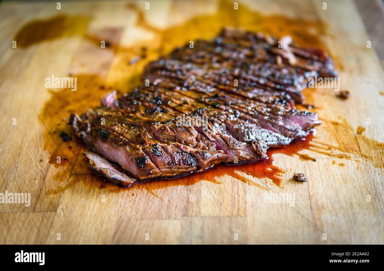 Tranches de bœuf Angus grillé mariné juteux steak de flanc sur planche de bois. Terminé la viande saignante juteuse est découpé et prêt à servir. G Professionnel Banque D'Images