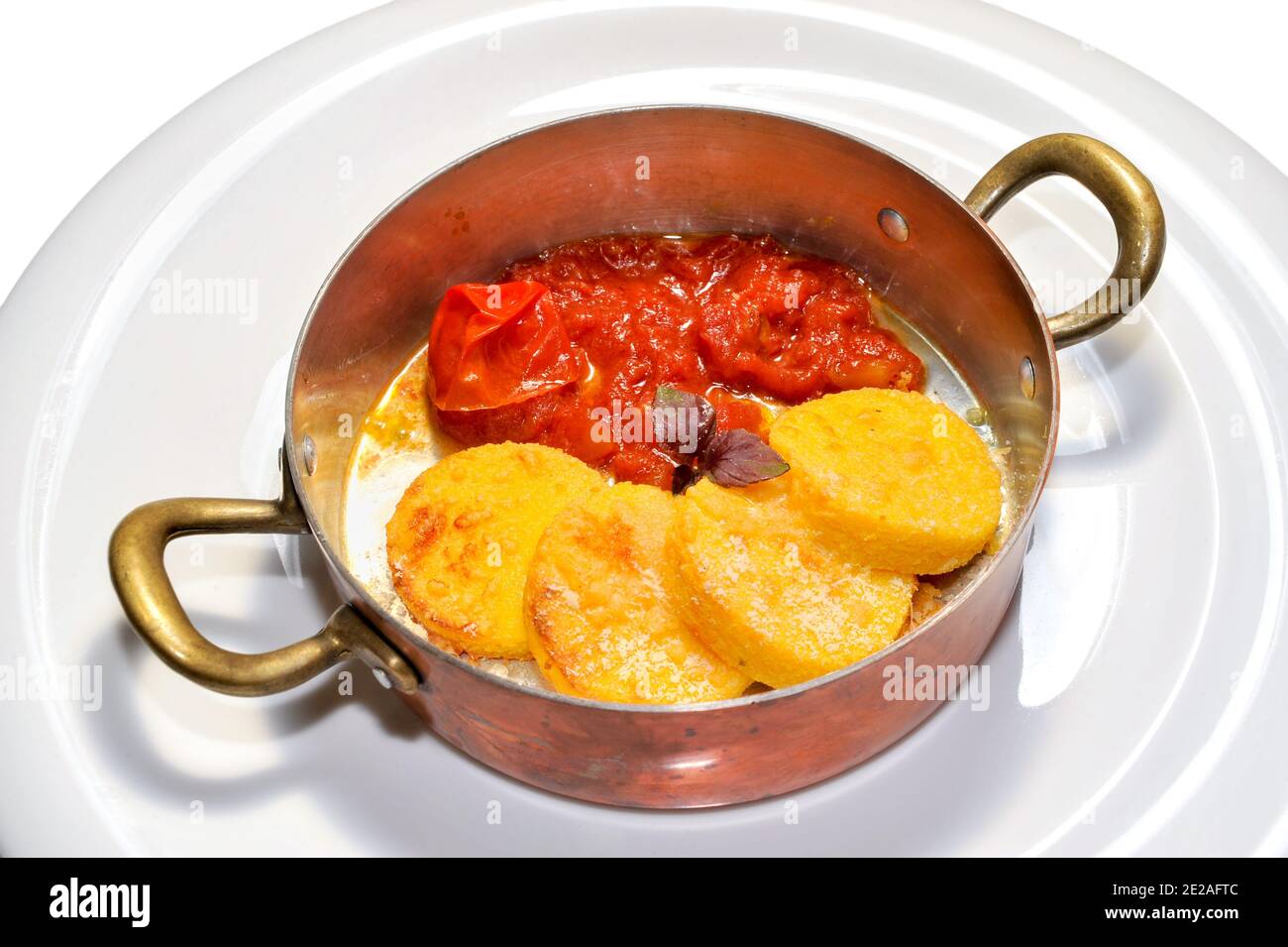 Gnocchi alla romana avec sauce tomate dans des ustensiles de cuisine en cuivre un arrière-plan blanc Banque D'Images