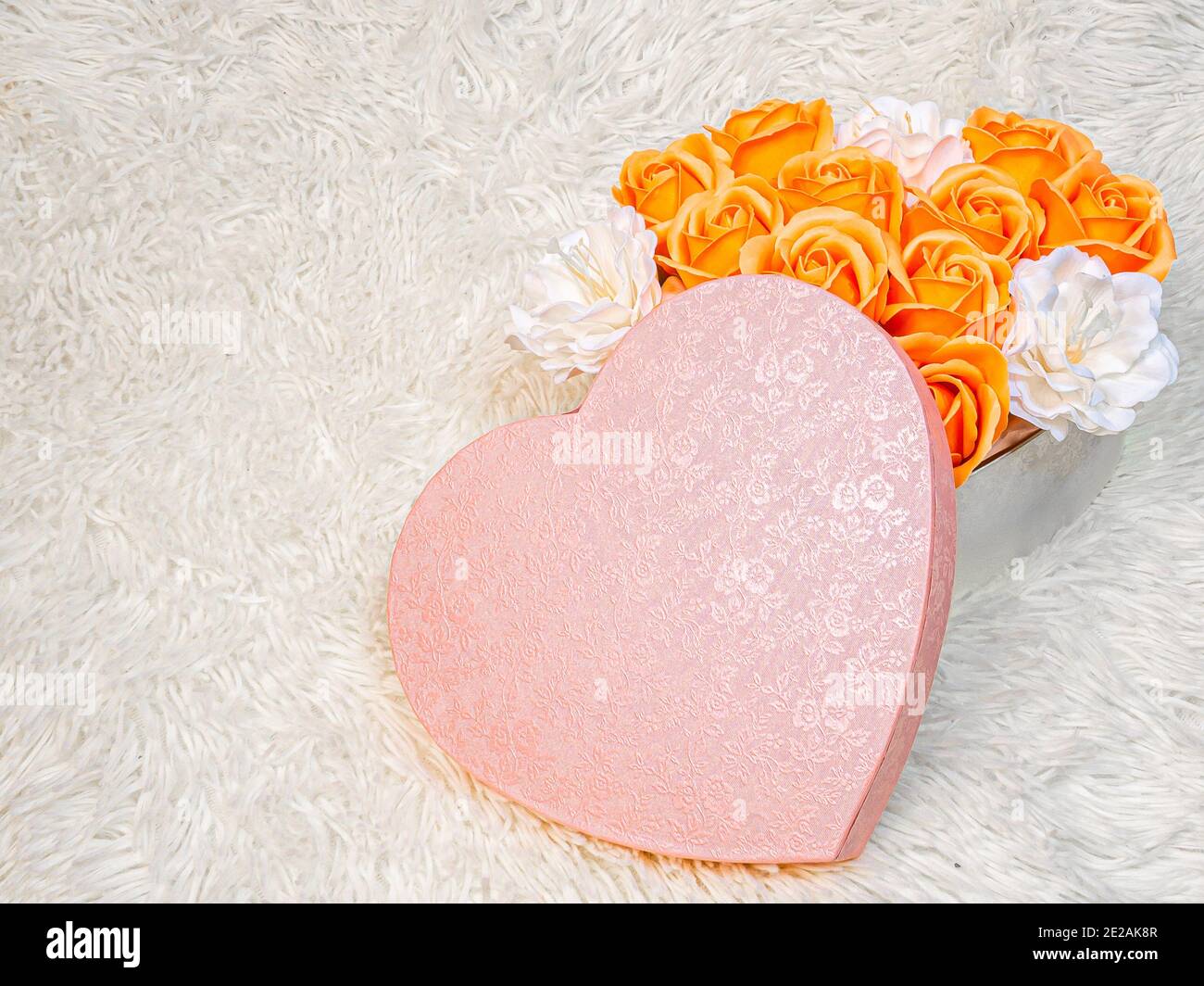 Roses orange et fleurs blanches dans une boîte rose en forme de coeur sur  un fond blanc de fourrure. Un cadeau romantique et doux pour votre  bien-aimé Photo Stock - Alamy