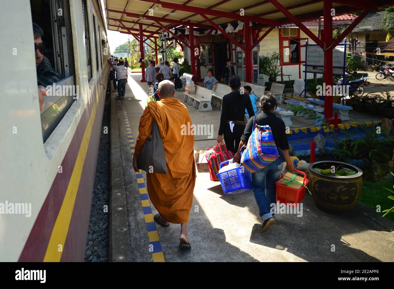 Monk marchant dans une gare en plus d'autres passagers, Hua Hin, Thaïlande. Banque D'Images