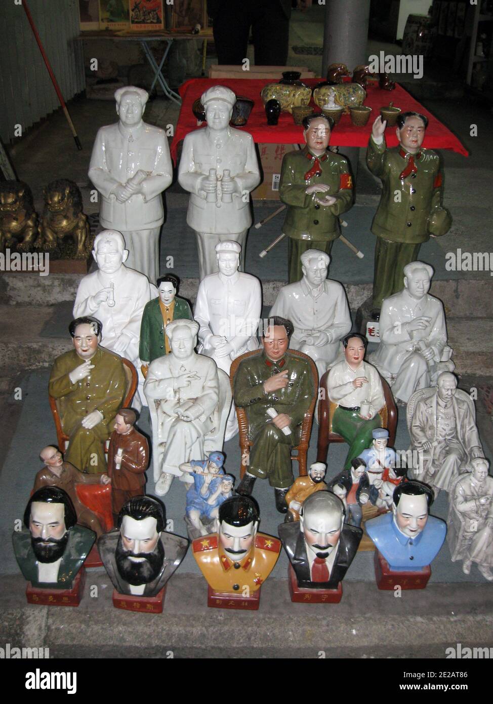 Collectant des objets du communisme (affiche, figurines, petit livre rouge de Mao Zedong) en vente sur un marché de rue de Hong Kong Banque D'Images