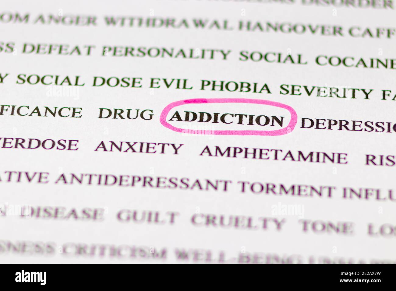 Mise en évidence du mot addiction dans un journal anglais avec un marqueur rose, vue du dessus à travers une loupe. Mauvaises habitudes, toxicomanie. Banque D'Images