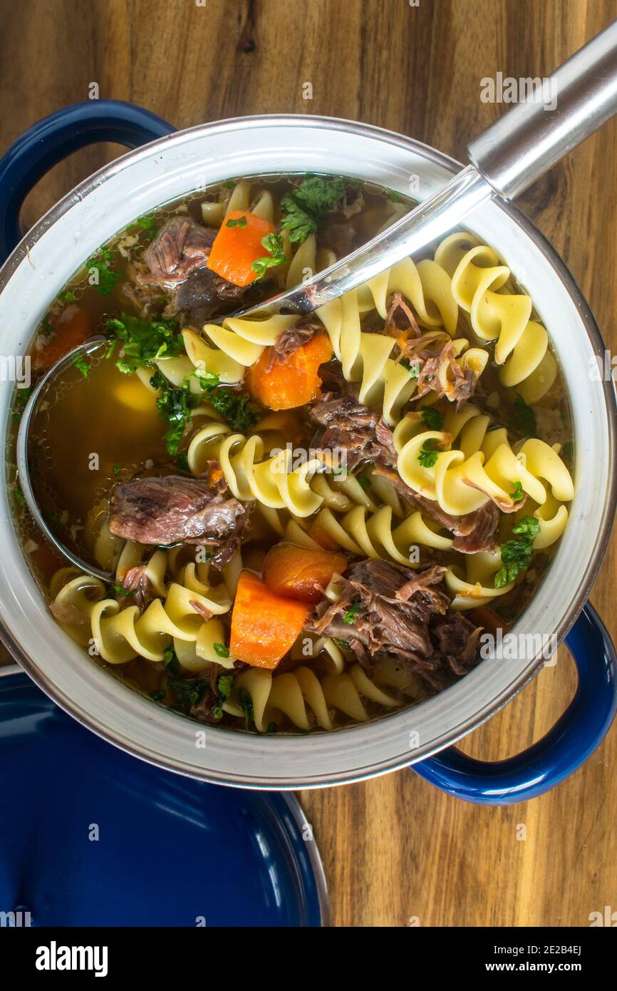 soupe traditionnelle de nouilles de bœuf fraîches cuites dans un pot vintage avec louche Banque D'Images