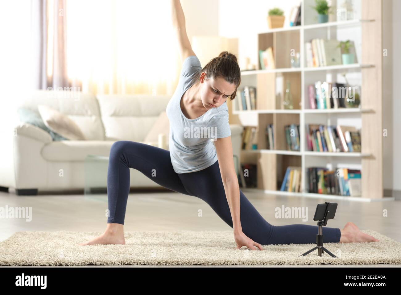 Femme frustrée e-learning yoga pose regarder le tutoriel vidéo en ligne sur smartphone à la maison Banque D'Images