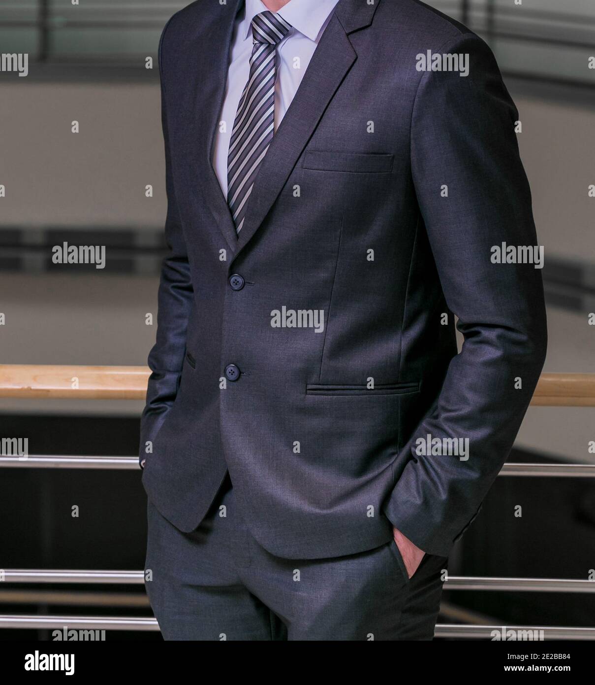 Photo verticale d'un homme d'affaires portant un costume bleu foncé avec  une chemise blanche et une cravate à rayures Photo Stock - Alamy