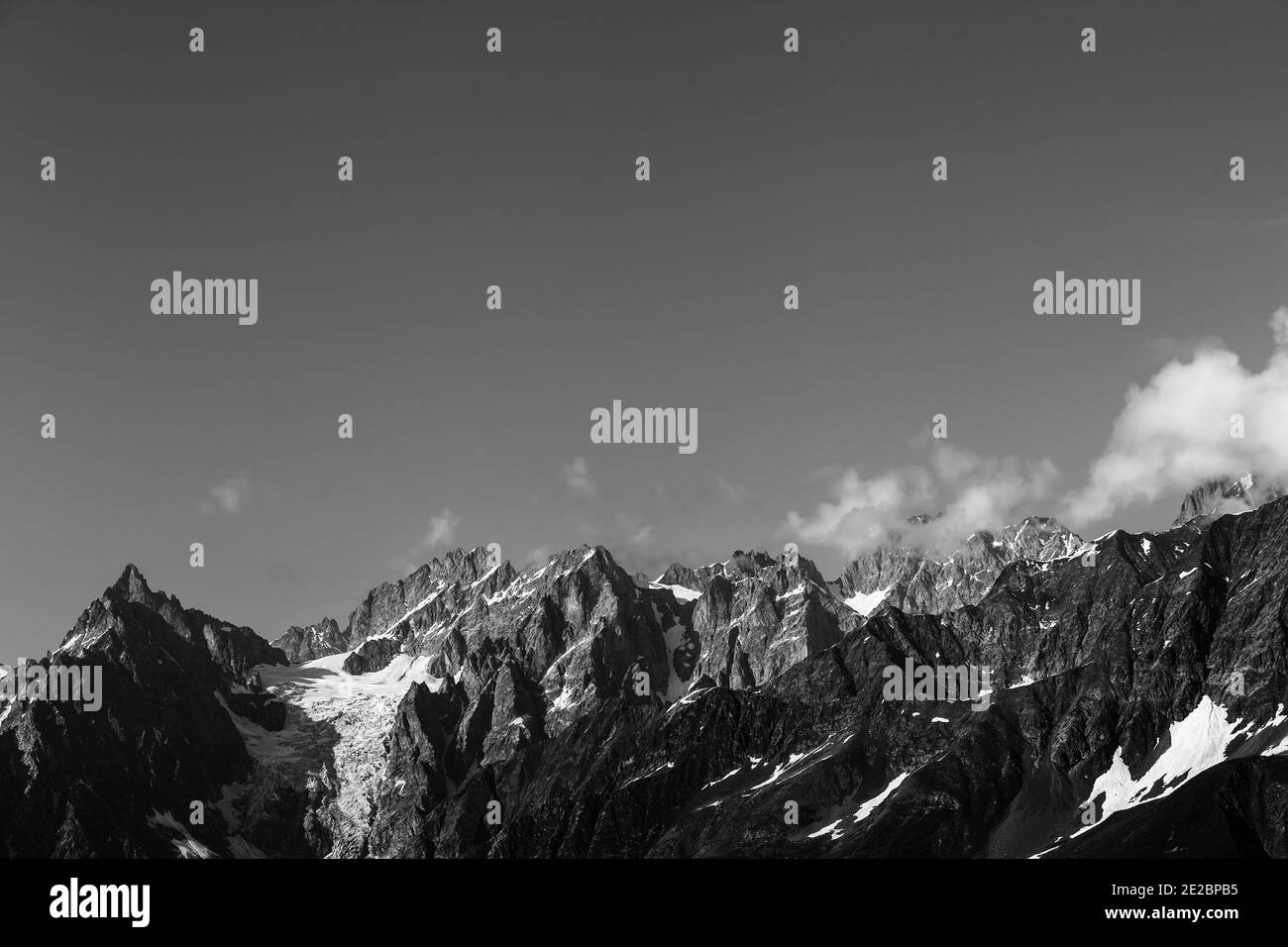 Hautes montagnes ensoleillées avec neige et glacier. Montagnes du Caucase. Géorgie, région de Svanetia en été. Emplacement distant. Paysage noir et blanc. Banque D'Images