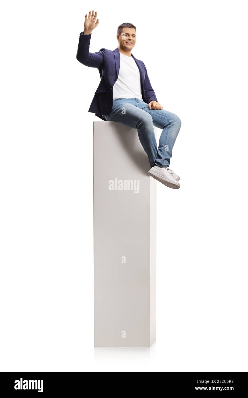 Jeune homme agitant d'une haute colonne blanche isolée sur arrière-plan blanc Banque D'Images