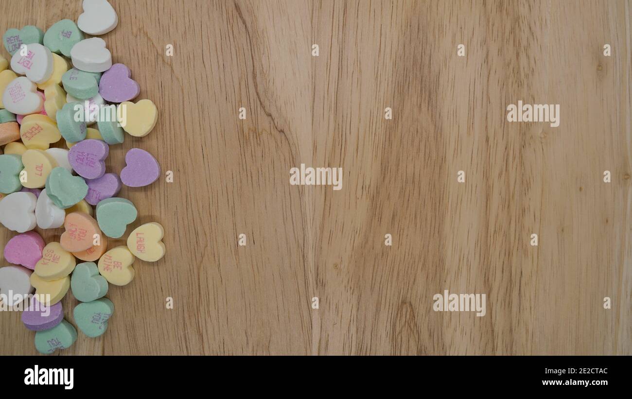 Les cœurs de conversation de bonbons forment une bordure sur un fond de bois Avec espace de copie pour un message de la Saint-Valentin Banque D'Images