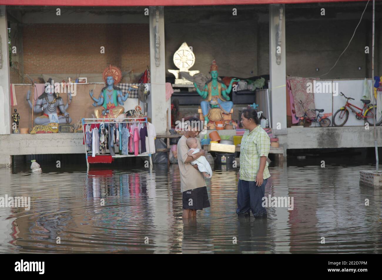 Les victimes des inondations traversent un quartier inondé dans un temple du district de Phatum Thani, dans le nord de Bangkok, alors que les eaux montantes menacent certaines parties de Bangkok, en Thaïlande, le 28 octobre 2011. Des centaines d'usines ont fermé dans la province centrale de la Thaïlande d'Ayutthaya et de Nonthaburi alors que les eaux d'inondation ont commencé à atteindre Bangkok. Selon le Département de la prévention et de l'atténuation des catastrophes, près de 370 personnes sont mortes dans des incidents liés aux inondations depuis la fin de juillet, la Thaïlande ayant connu les pires inondations depuis 50 ans. Photo de Frédéric Belge/ABACAPRESS.COM Banque D'Images