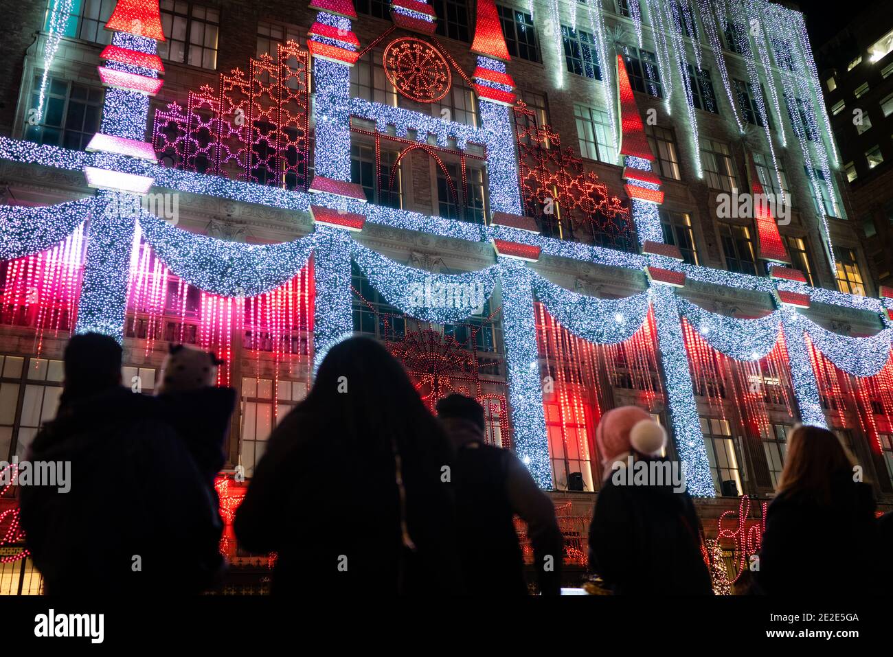 NEW YORK, ÉTATS-UNIS - 19 décembre 2020 : les visiteurs regardent une exposition de lumière sur la façade du magasin Saks Fifth Ave avant Noël à New York Banque D'Images