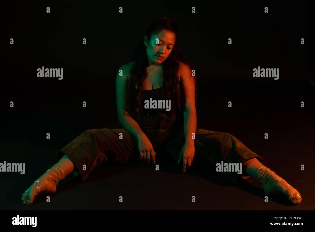 Jeune et attrayant modèle féminin adulte posé dans l'éclairage de studio réglage Banque D'Images