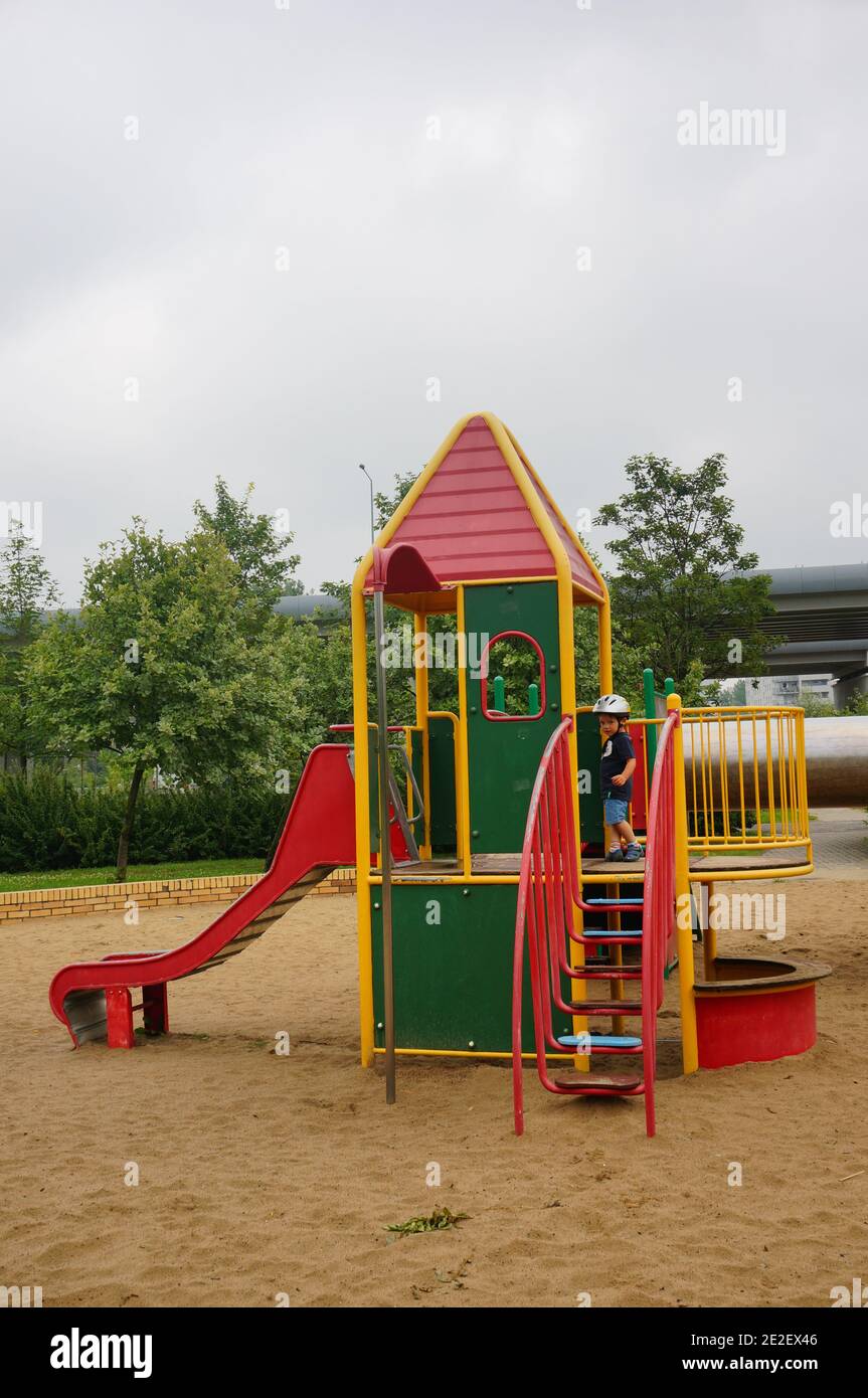 POZNAN, POLOGNE - 23 juillet 2017 : équipement coloré dans une aire de jeux avec un enfant dans un parc Banque D'Images
