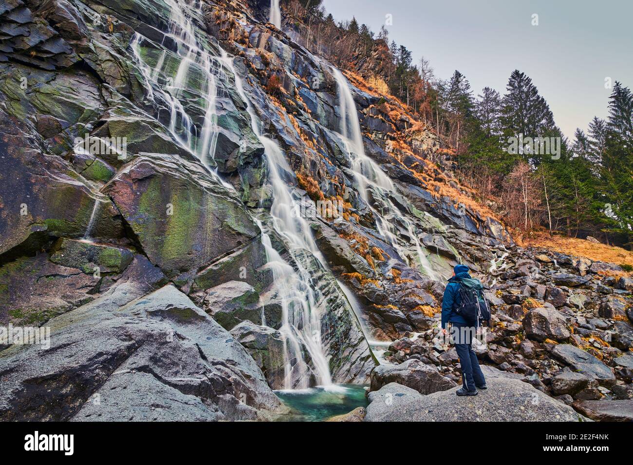 Jeune homme admirant les chutes d'eau de Nardis à Val di Genova, dans le parc naturel d'Adamello-Brenta, dans le nord de l'Italie Banque D'Images