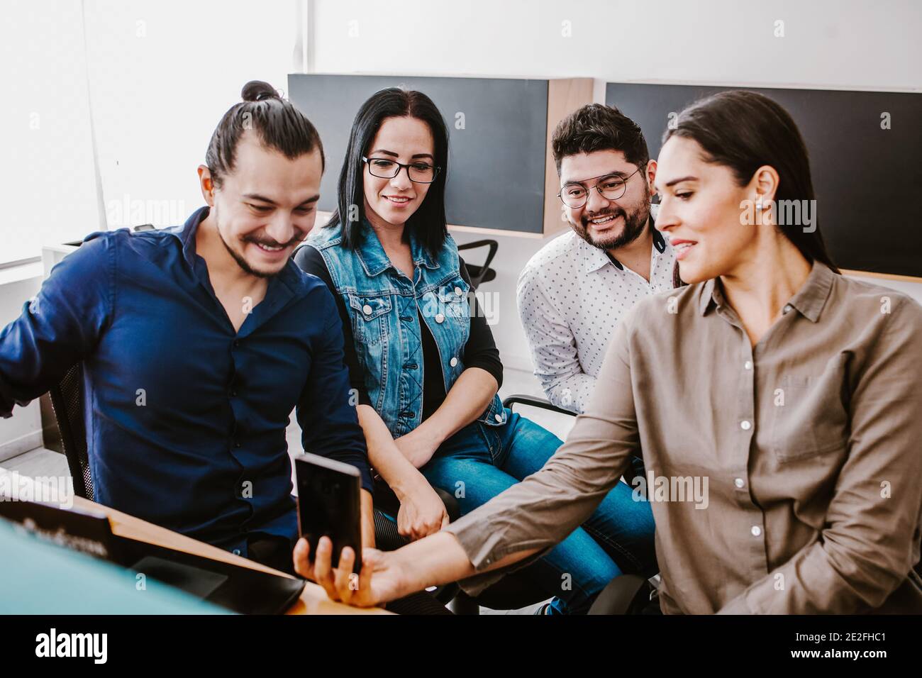 Groupe de gens d'affaires latins travaillant ensemble comme un travail d'équipe tout en étant assis au bureau dans un bureau créatif À Mexico Banque D'Images Groupe de gens d'affaires latins travaillant ensemble comme un travail d'équipe tout en étant assis au bureau dans un bureau créatif À Mexico Banque D'Images