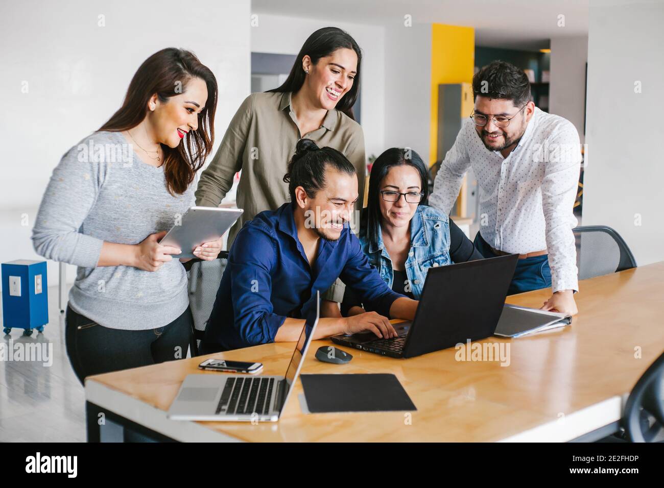 Groupe de gens d'affaires latins travaillant ensemble comme un travail d'équipe tout en étant assis au bureau dans un bureau créatif À Mexico Banque D'Images Groupe de gens d'affaires latins travaillant ensemble comme un travail d'équipe tout en étant assis au bureau dans un bureau créatif À Mexico Banque D'Images
