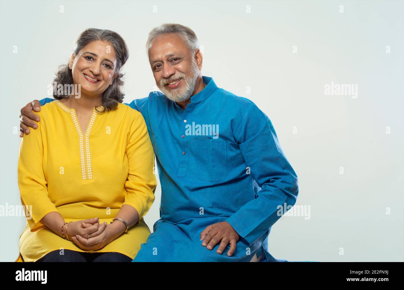 UN COUPLE SENIOR SE FAIT UN PLAISIR DE REGARDER LA CAMÉRA ET DE SOURIRE Banque D'Images