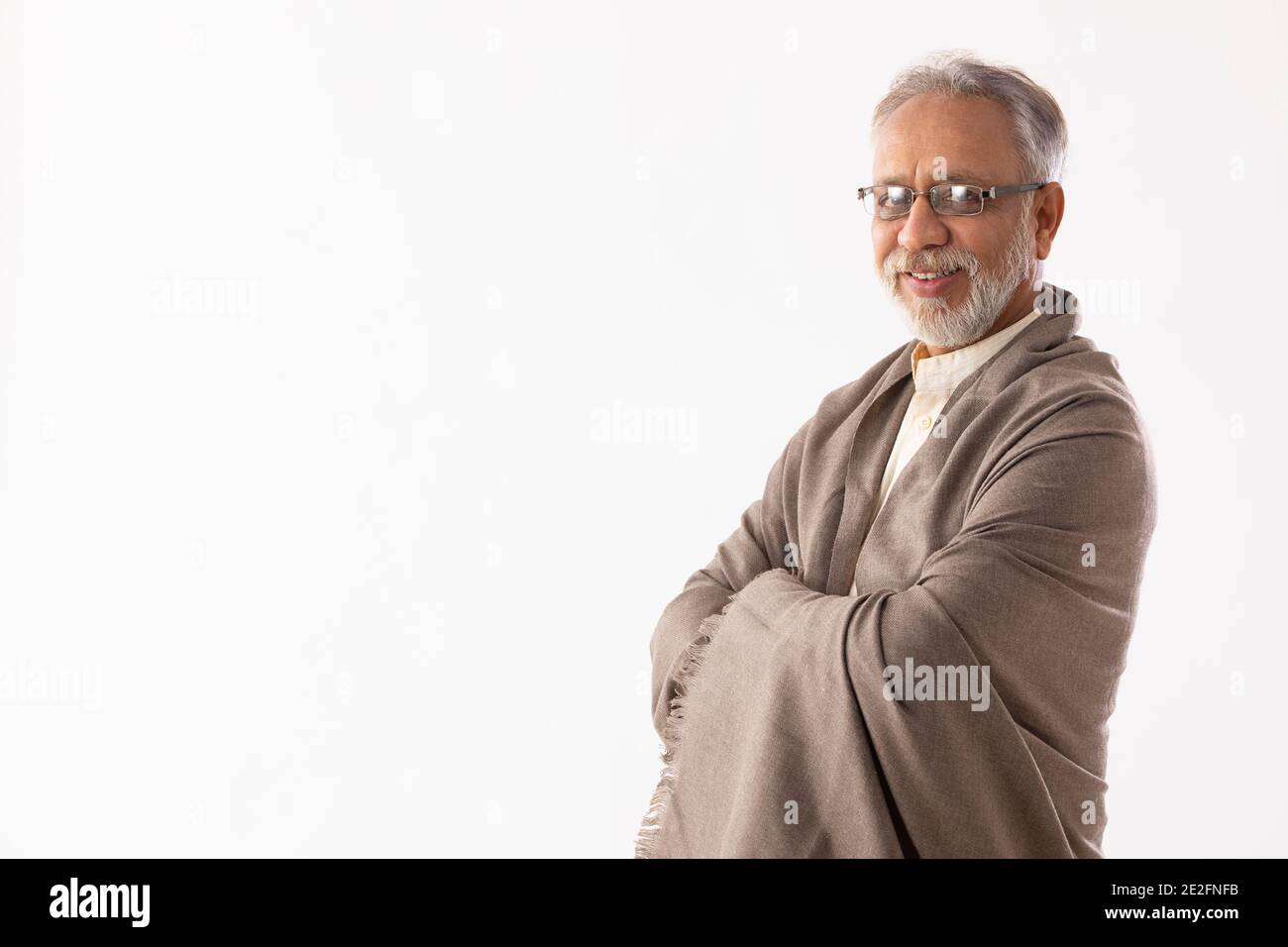 UN VIEIL HOMME HEUREUX DEBOUT ET SOURIANT À LA CAMÉRA Banque D'Images