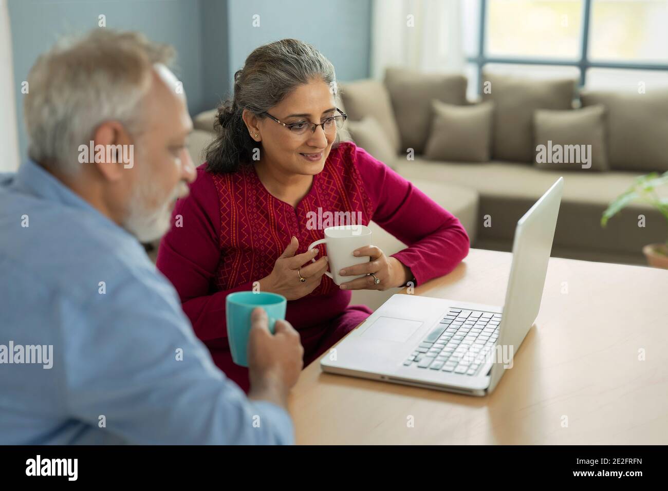 UNE FEMME ADULTE ET UN MARI ÂGÉS REGARDANT L'ORDINATEUR PORTABLE ENSEMBLE Banque D'Images