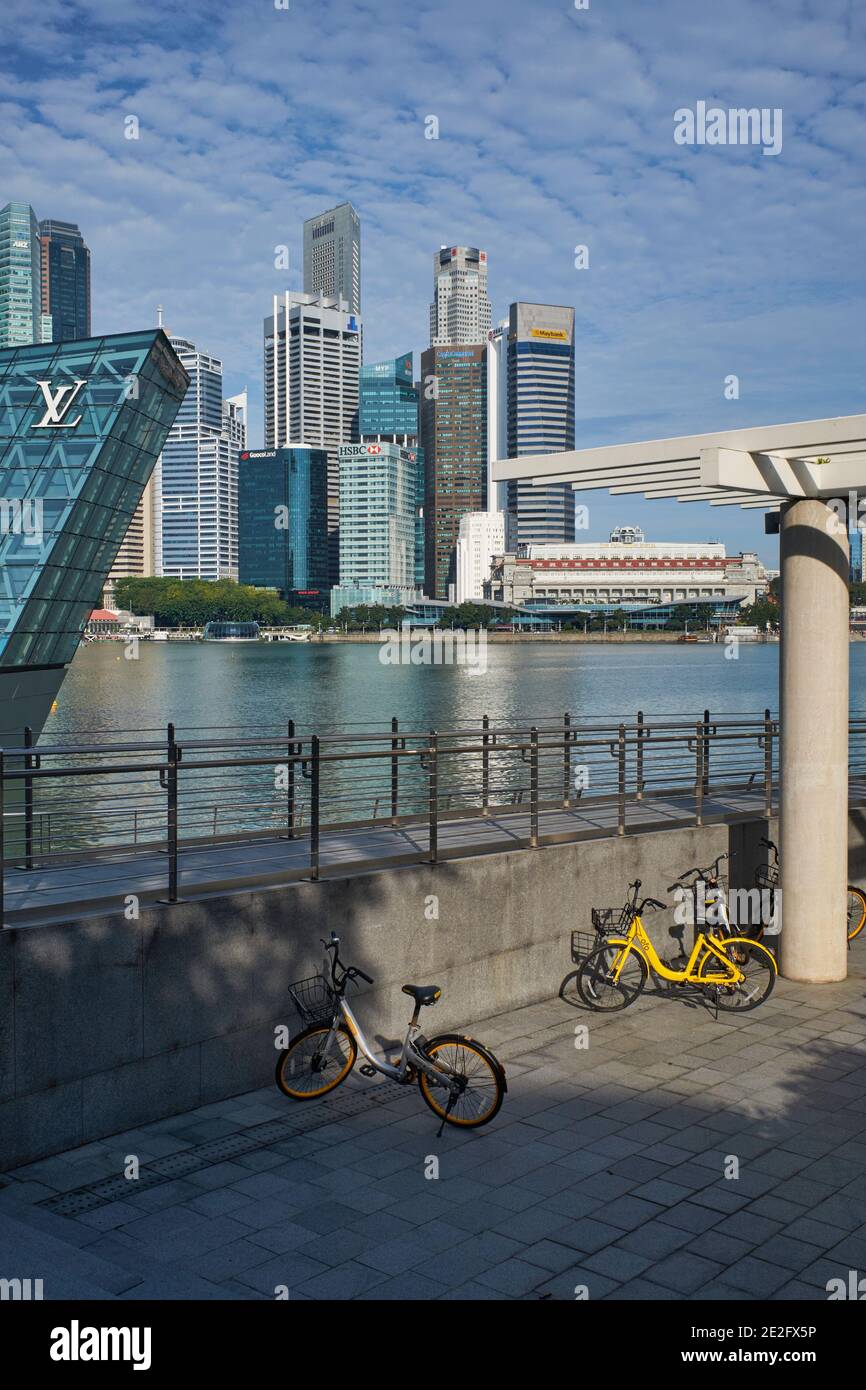 Vélos garés à Marina Bay, Singapour, les hauts immeubles du quartier bancaire en arrière-plan Banque D'Images