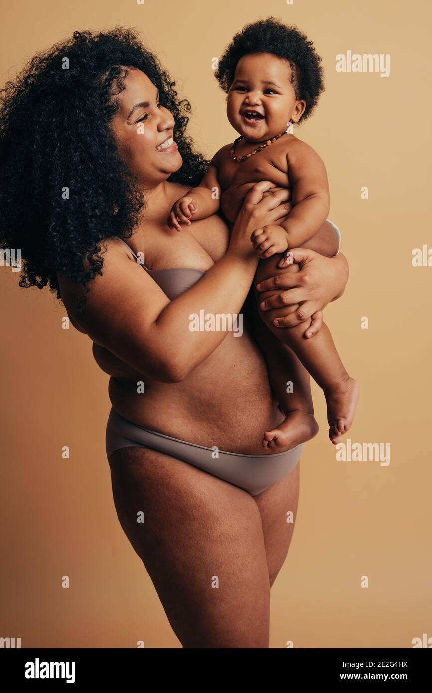 Mère africaine et bébé debout ensemble le jour des mères. Maman et enfant souriant exprimant bonheur et amour. Banque D'Images