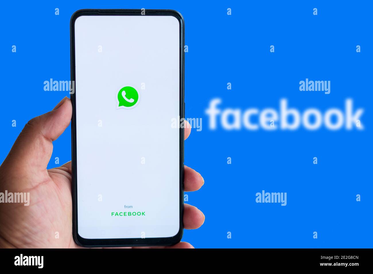 Katmandou, Népal - janvier 14 2021: L'homme tient smartphone avec le logo WhatApp contre le logo Facebook en arrière-plan. Banque D'Images