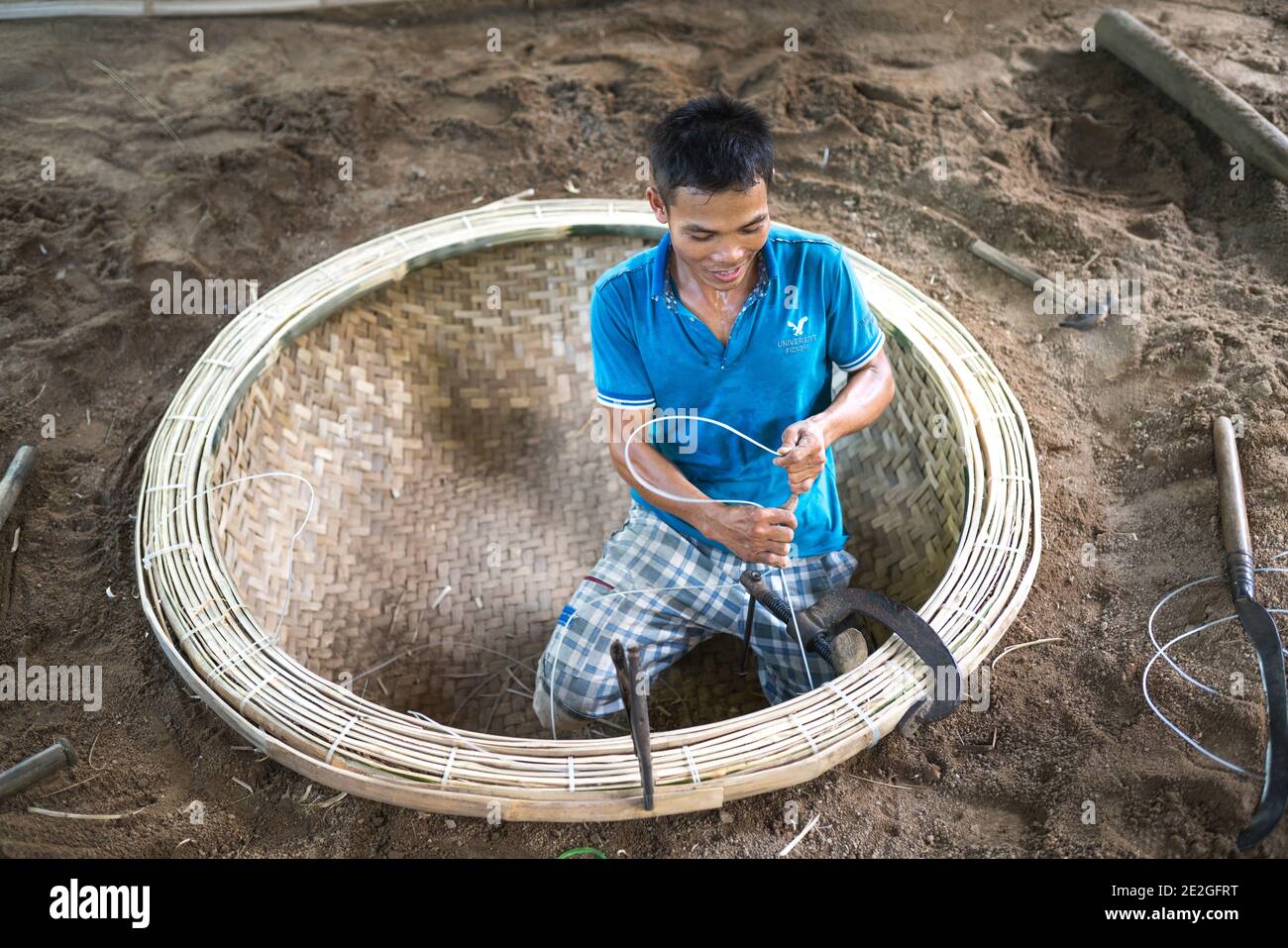 Province de Phu yen, Viet Nam - le 9 juillet 2017 : un artisan qualifié est  en train de fabriquer un panier en bambou avec des outils à main tels que  des