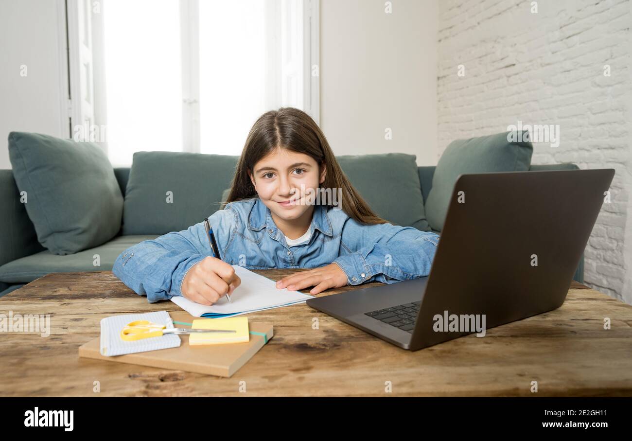 Bonne fille Teen sur ordinateur portable étudiant en ligne dans la télécommande virtuelle cours sur internet à la maison comme l'école secondaire restent fermé en raison du dernier lockd du coronavirus Banque D'Images