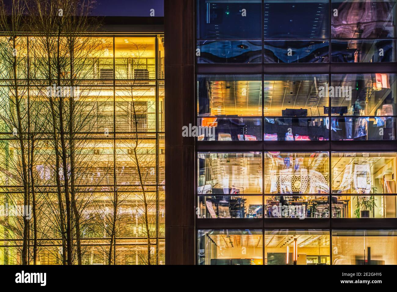 Bureau contemporain avec façade vitrée la nuit dans le quartier financier. Bâtiment moderne ou siège social où les gens investissent ou font du commerce dans des entreprises Banque D'Images
