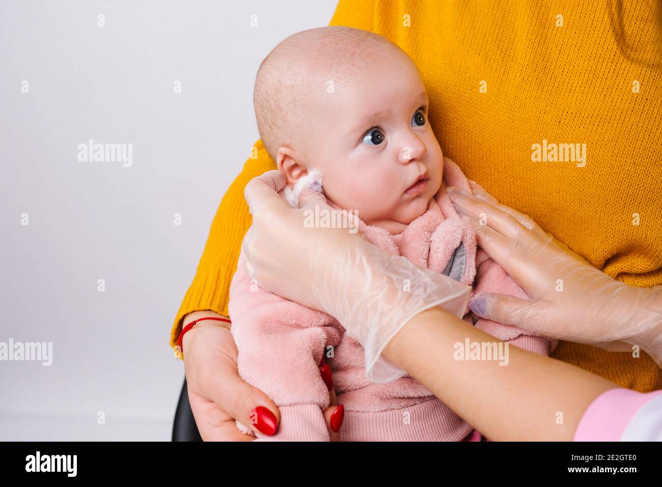 Photo Agrandie D Une Petite Fille De Bebe Mignonne Dont Les Mains Du Medecin Frottent Son Oreille En Preparation Pour Le Percage D Oreille Procedure De Beaute Photo Stock Alamy