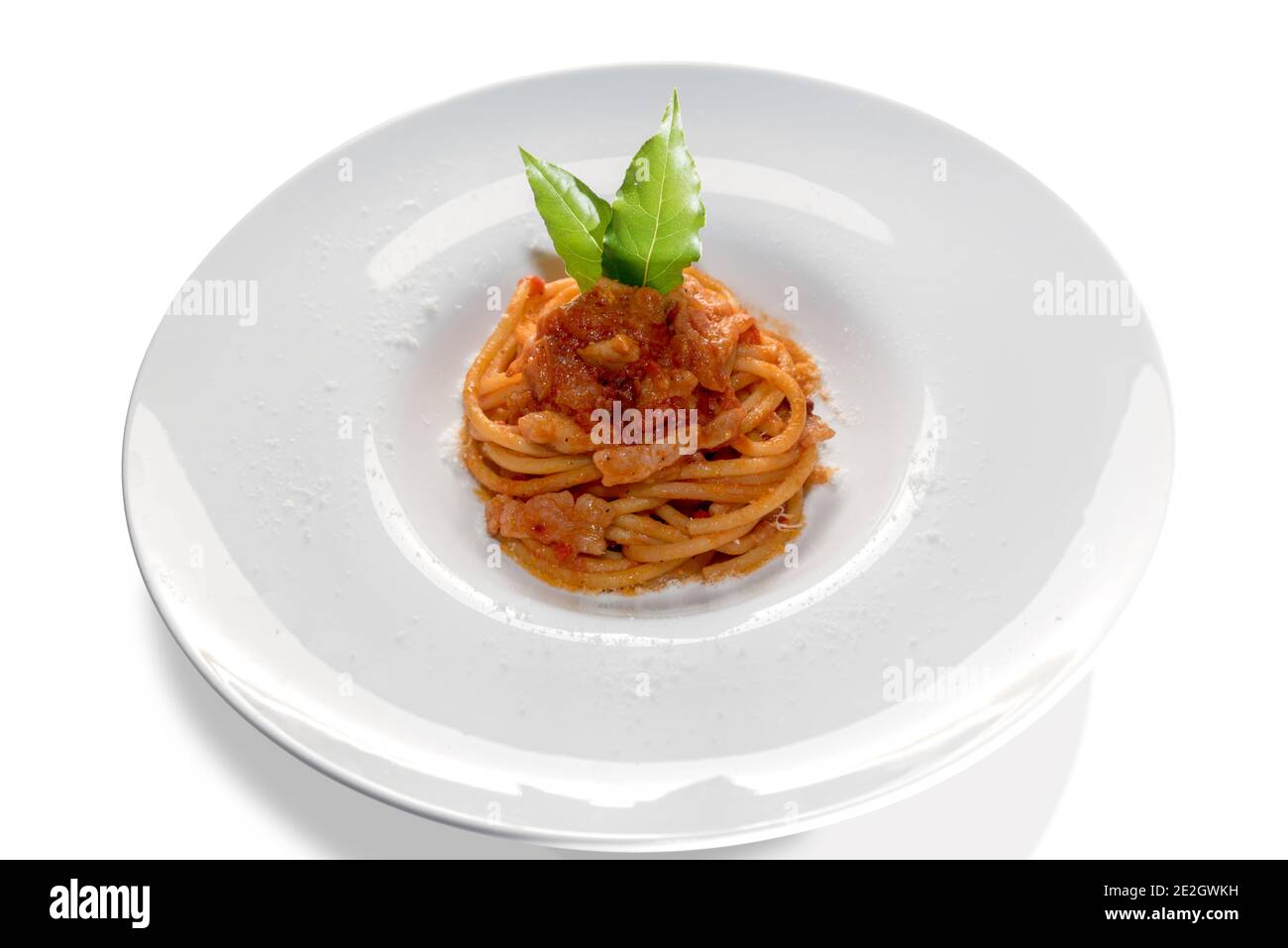 Bucatini Amatriciana pâtes avec feuilles de baie dans un plat blanc isolé sur blanc Banque D'Images