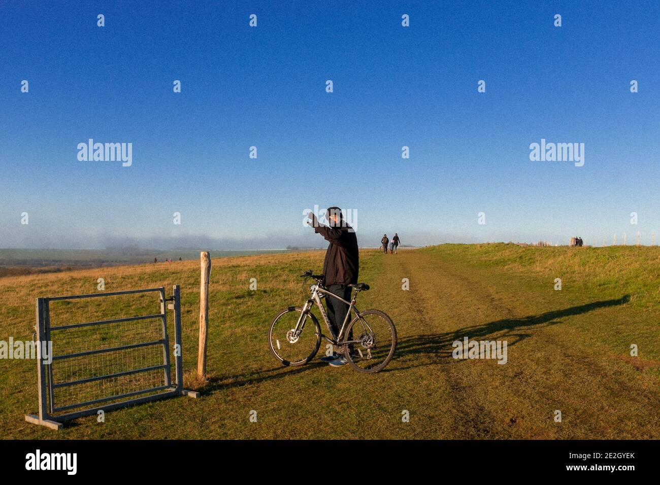 Jeune homme avec son vélo à côté de la porte sans clôture, East Brighton Gold Club, Brighton & Hove, East Sussex, YJ Banque D'Images