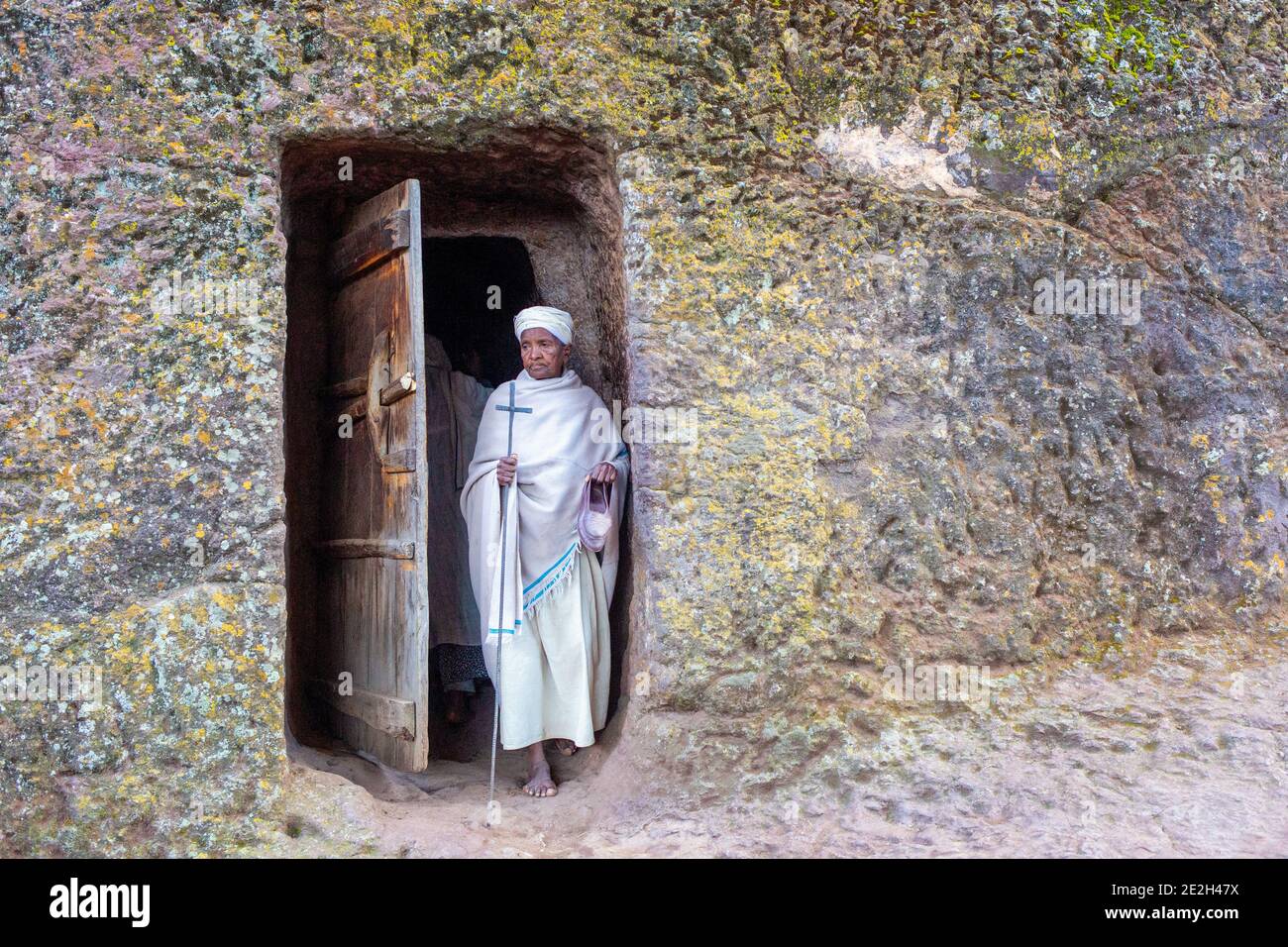 Vieux pèlerin marchant pieds nus à l'église Rock-hewn Felsenkirche site du patrimoine mondial de l'UNESCO, Lalibela, Ethiopie, Afrique Banque D'Images
