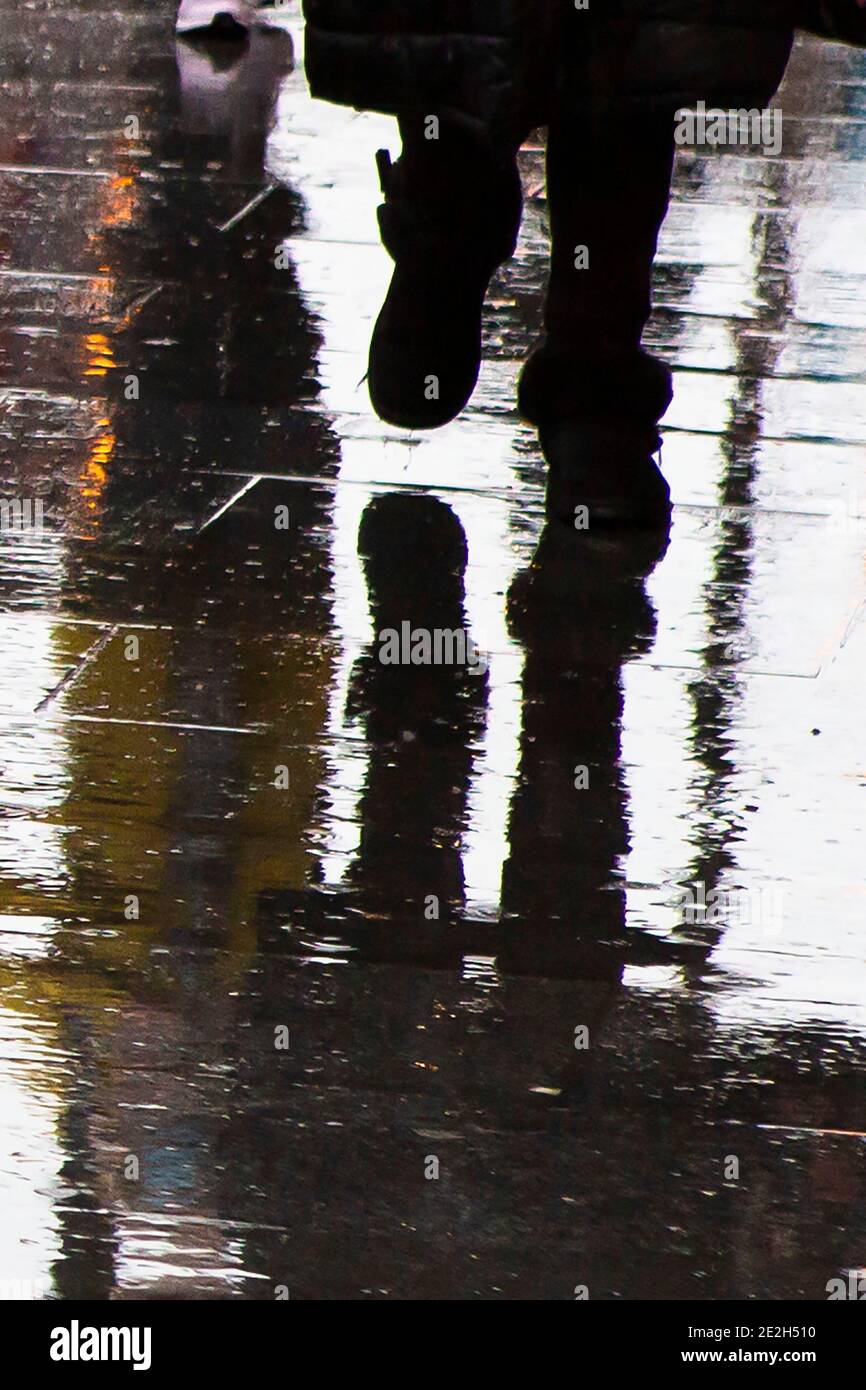 Reflet de la silhouette des pieds dans une flaque Banque D'Images